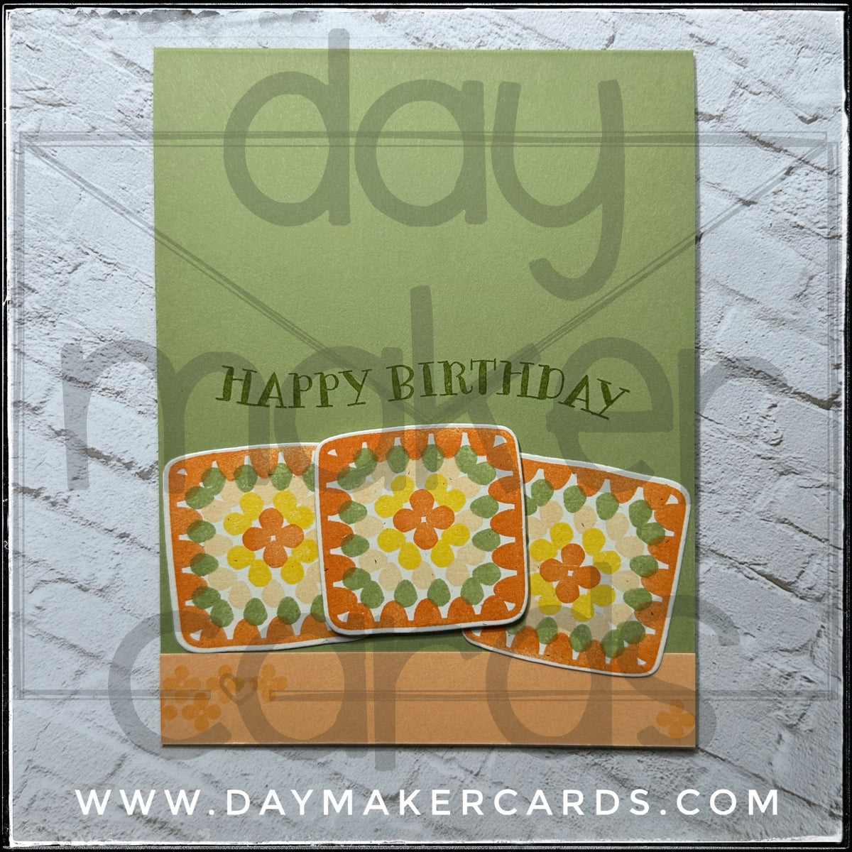 Handmade birthday card with granny square designs and 'Happy Birthday' text on a soft green background, featuring Day Maker Cards branding.