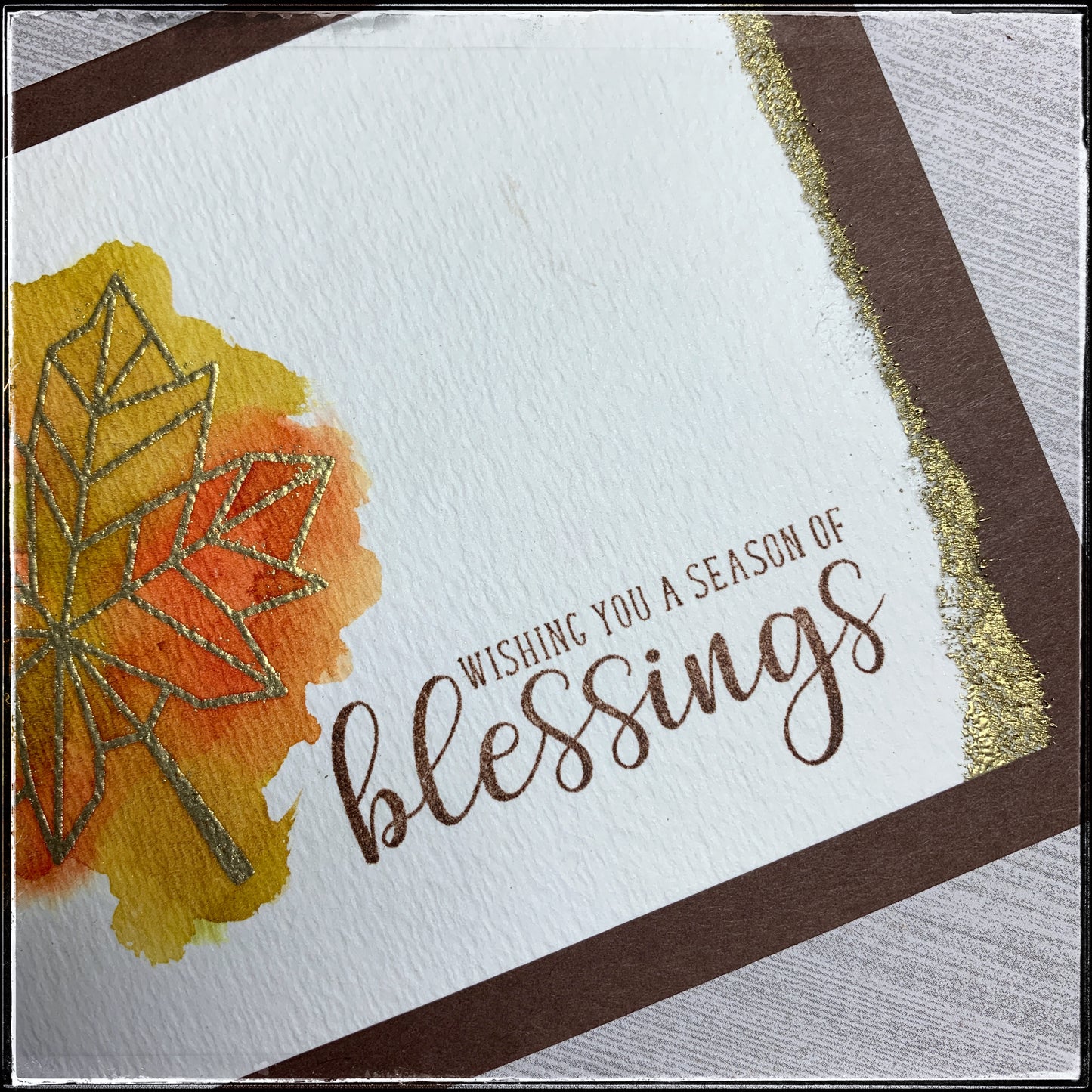 A close up of the detail on the front panel of this card, featuring a torn edge that's been heat embossed with gold powder on this handmade card from 1cre8ivemess. 